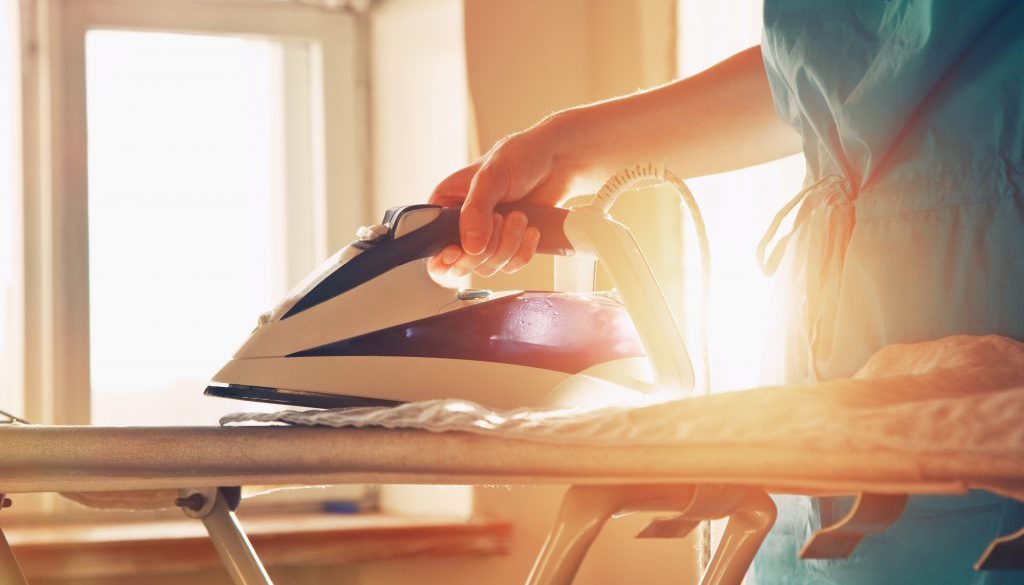 A person ironing clothes on a board